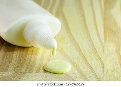 Tube Of Glue Dripping Drop On Wooden Board, Carpentry Concept, Spot Focus, Close Up Applying Glue On The Wood