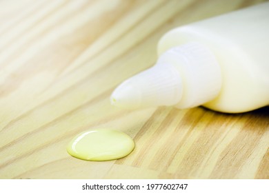 Tube Of Glue Dripping Drop On Wooden Board, Carpentry Concept, Spot Focus