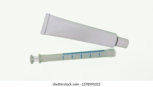 Tube of ointment and cannula for vaginal use isolated in white background