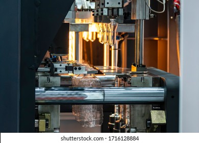 The tube preform shape of bottles preheat process on the production line to the automatic blowing machine. The operation of PET bottle processing by blowing process with the blowing mold.  - Powered by Shutterstock