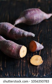 Tubers Of Sweet Potato Or Yams On A Dark Wooden Background. Jewel Yams 