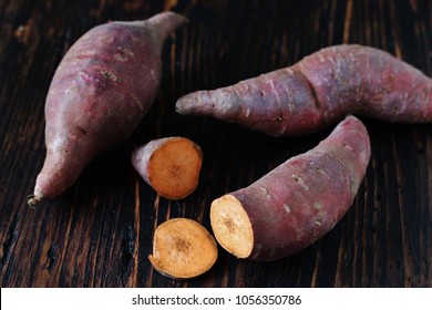 Tubers Of Sweet Potato Or Yams On A Dark Wooden Background. Jewel Yams 