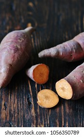 Tubers Of Sweet Potato Or Yams On A Dark Wooden Background. Jewel Yams 