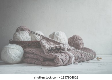 Tubes of wool thread and knitting needles for knitting handmade hobby in Scandinavian style monochrome with copy space