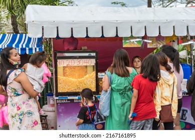 Tubigon, Bohol, Philippines - May 2022: A Family Orders Popcorn From A Stand. Activities During The Town Fiesta.