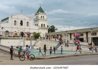 Tubigon, Bohol, Philippines - May 2022: A Bunch Of People Near St. Isidore The Farmer Church During The Town Fiesta.