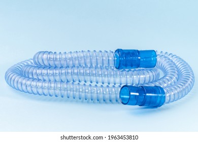 Tubing for CPAP or BIPAP machine with green filter isolated on blue background. Medical equipment