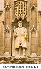 A Tudor Statue Of King Henry VIII On The Great Gate To Trinity College, Cambridge.  His Gold Sceptre Has Been Replaced By A Chair Leg As A Prank.  The College Is Part Of Cambridge University.