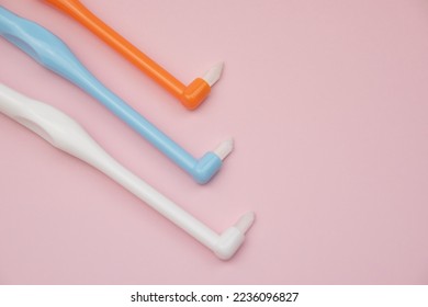 Tuft toothbrushes on pink, tufted  tapered trim toothbrush, single compact interdental interspace brush for detail cleaning - Shutterstock ID 2236096827