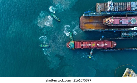 Tug boat drag pull cargo container ship from dry dock concept maintenance service working in the sea. Insurance and Maintenance Cargo Ship concept. Freight Forwarding Service maintenance Insurance