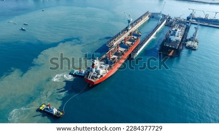 Tug boat Draging cargo container ship to dry dock concept maintenance service working in the sea. Insurance and Maintenance Cargo Ship concept. Freight Service maintenance Insurance