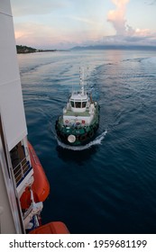 Tug Boat Guiding A Tourist Ship Into Port At Tahiti In The Early Morning.