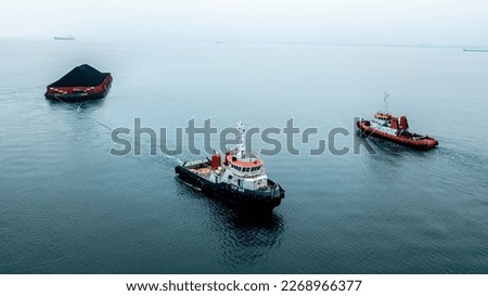 Tug boat pulling barge coal sea assisting