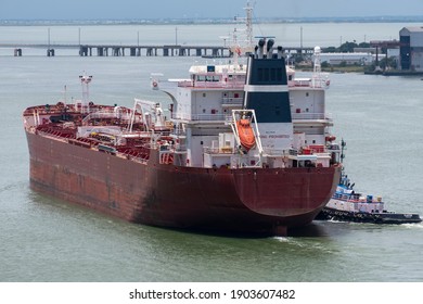 Tug Boat Pushing A Cargo Ship