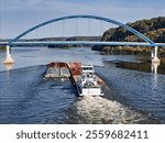 Tug boat pushing a set liquid tank cargo barges up the Mississipppi river traveling under the Dale Gardner Veterans Memorial Bridge at Savanna illinois 