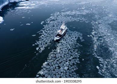 Tug Boat Pushing Through The Ice On A Sea In Winter