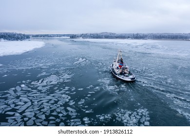 Tug Boat Pushing Through The Ice On A Sea In Winter