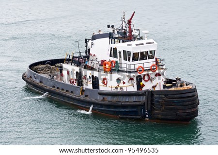 A tug boat stands ready to help ships in the Panama Canal