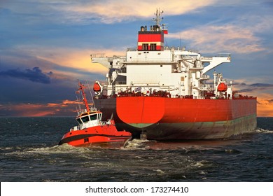 Tug Boat Towing A Tanker Ship At Sea.