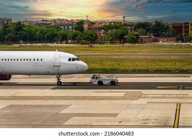 TUG Pushback Tractor With Aircraft On The Runway In Airport.