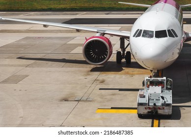 TUG Pushback Tractor With Aircraft On The Runway In Airport.