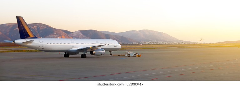 TUG Pushback Tractor With Aircraft On The Runway In Airport.