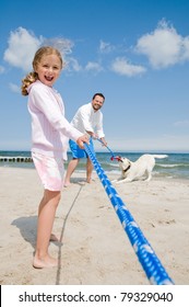 Tug Of War - Family With Dog Playing On The Beach