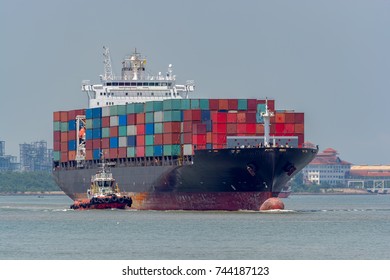 Tugboat assist a container vessel on the way out of the harbor. - Powered by Shutterstock