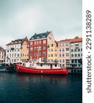 Tugboat moored in front of colorful buildigns at Nyhavn Canal, Copenhagen, Denmark
