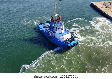 A tugboat in port stands ready alongside the ship waiting to provide support
 - Powered by Shutterstock