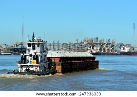 A Tugboat pushes a barge down the Mississippi River at New Orleans.