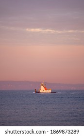 A Tugboat In Seattle Moving West Through Puget Sound At Sunrise