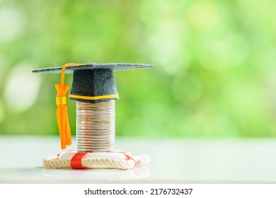 Tuition protection service and tuition refund insurance, financial concept : Black graduation cap or a mortarboard placed higher on top of a coin stack with a red lifebuoy on a table, green background - Shutterstock ID 2176732437