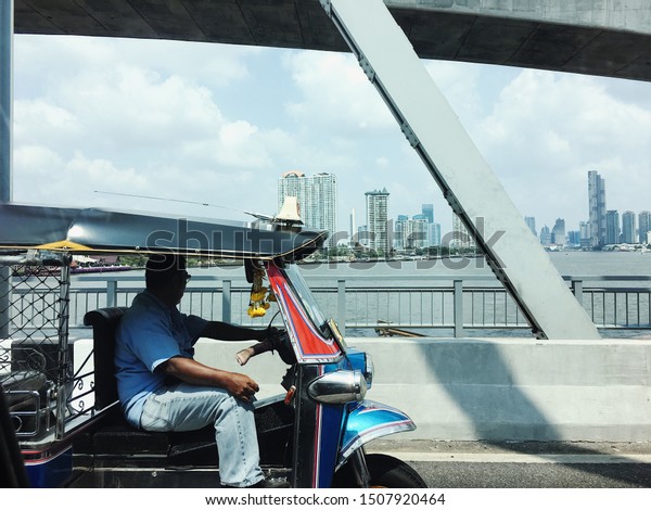Tuk Tuk driver on the\
bridge in Bangkok