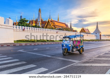 Tuk Tuk is parking in front of Wat Phra Kaeo or Grand Palace, Bangkok, Thailand. This is a beautiful scene of the palace with the twilight sky.