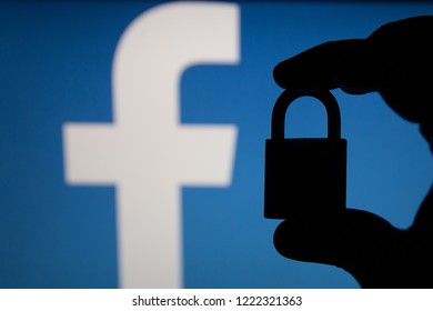 Tula, Russia - August 28, 2018: Facebook security issues. Silhouette of a hand holding a padlock infront .