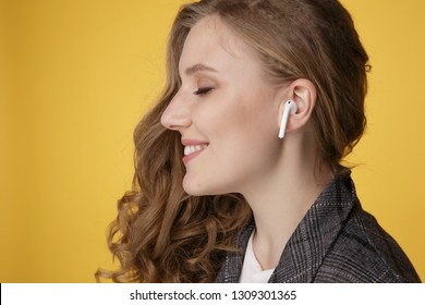 Tula, Russia - JANUARY 24, 2019: Happy woman listening music Apple AirPods wireless .