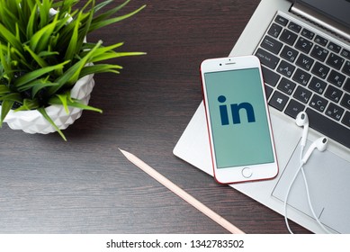 Tula, Russia, March 12, 2019: Linkedin logo on the iphone 7 screen is placed on the laptop keyboard next to EarPods in the office. - Image