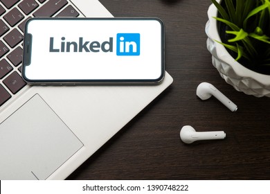 Tula, Russia, May 1, 2019: LinkedIn logo on the iphone X screen is placed on the laptop keyboard next to AirPods.- Image