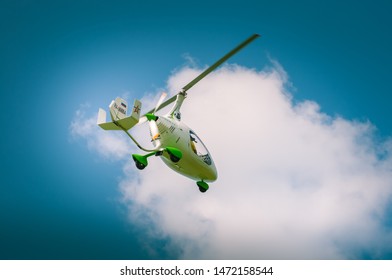 Tula, Tulskaya oblast / Russia - 27 june 2019: white autogyro flight at airshow. Gyrocopter goes gown in blue sky with clowds