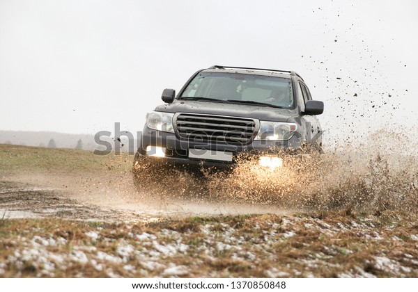 Tula/Russia - APRIL 14,\
2019\
Toyota Land Cruiser 200 drives in the puddle at fast speed.\
off-road car driving through a puddle. water splashes from under\
the wheels of the\
car