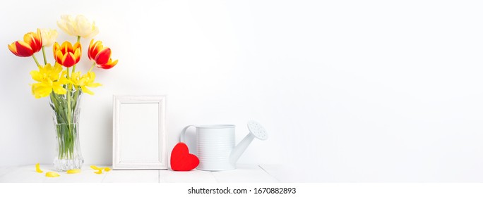 Tulip Flower In Glass Vase With Picture Frame Place On White Wooden Table Background Against Clean Wall At Home, Close Up, Mother's Day Decor Concept.