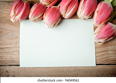 Tulips and blank card on old wooden boards - Powered by Shutterstock