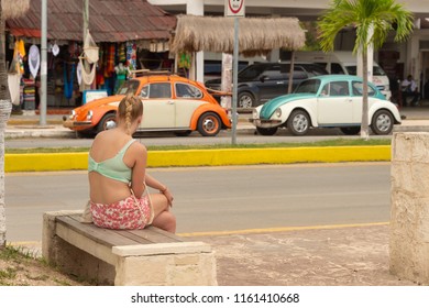 Tulum, Mexico - 7 August 2018: Young Woman Sitting On A Bench On Avenida Tulum.