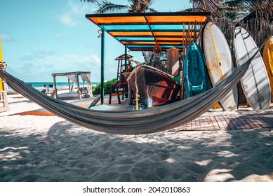 Tulum, Mexico. May 25, 2021. Hanging Empty Hammock With Boat And Canoe On Sand At Beautiful Mexican Beach Resort