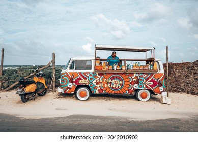 Tulum, Mexico. May 25, 2021. Chef Or Vendor Preparing Food In A Colorful And Decorative Vintage Food Truck In Front Of Beach Next To A Parked Scooter