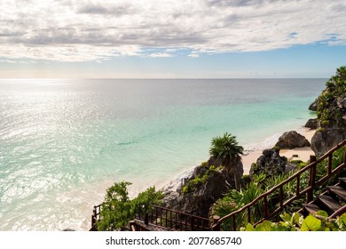 The Tulum Ruins Beach as seen from the Tulum Ruins on a beautiful day with clouds in the sky.
