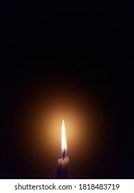 TULUNGAGUNG, INDONESIA - SEPTEMBER 20th 2020 - A White Candle Burning In The Dark Of The Night