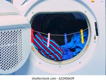 Tumble Dryer Versus Traditional Way Of Drying Laundry. Dryed Clothes In Tumble Dryer  And Clothesline With Clothespins. 