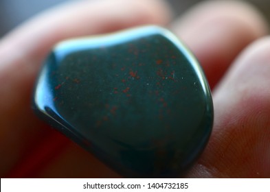 Tumbled Bloodstone, Premium Quality Polished Bloodstone great for wealth, abundance, and prosperity. Tumbled healing crystal being held in hand. 